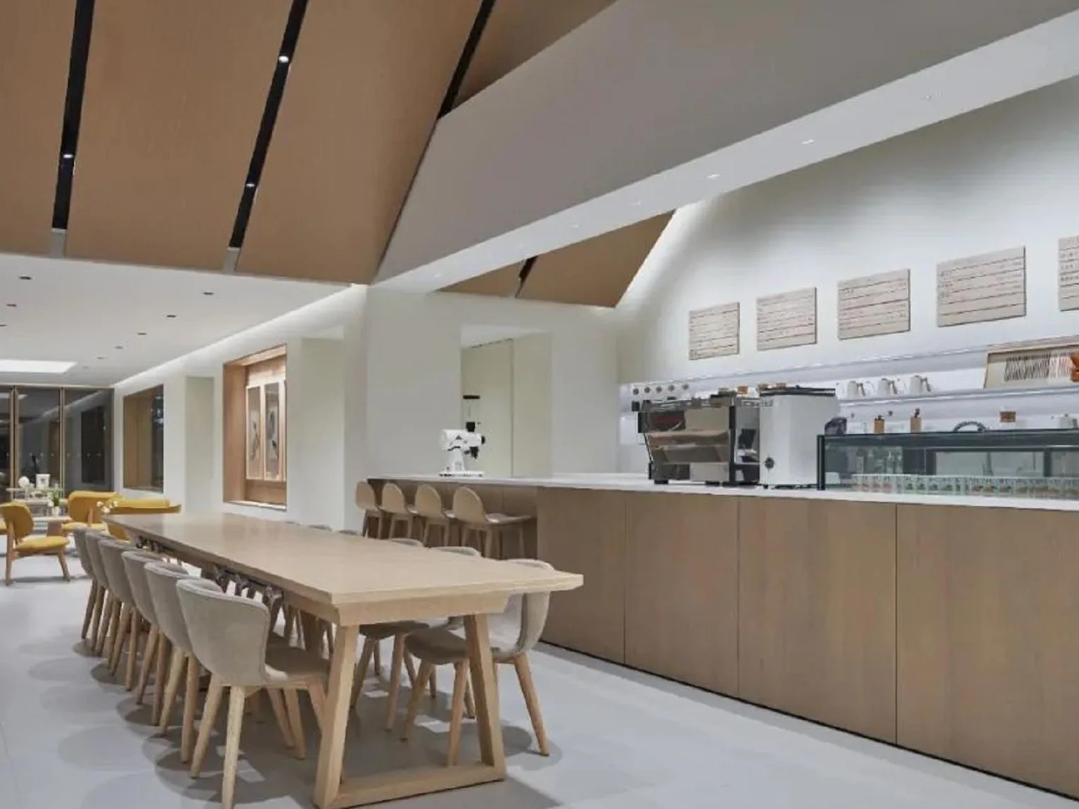 Coffee and lounge area illuminated with recessed downlights and track lighting.