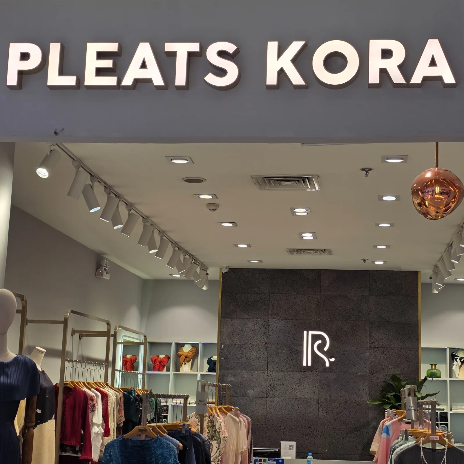 Front view of the PLEATS KORA fashion boutique featuring SPECTRUM LED track lights