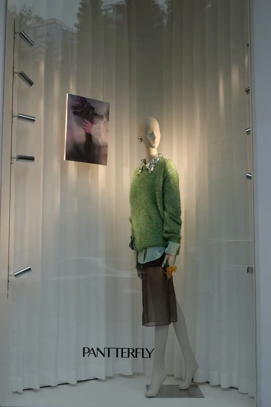 Store window display featuring a mannequin highlighted by EMMA Magnetic Track Lights and SILO Downlights.