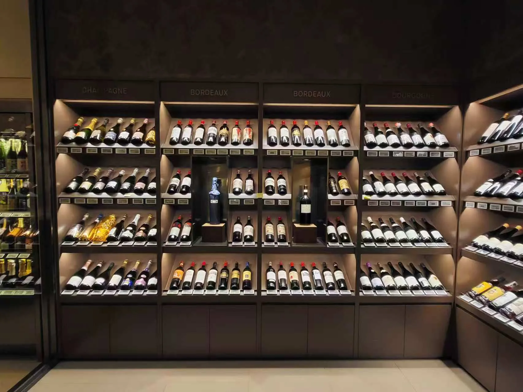 Premium wine display shelves illuminated by SLIM linear lighting and recessed downlights.