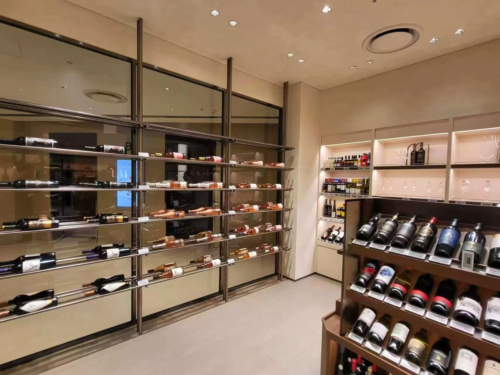 Wine display shelves featuring ULTRA-SLIM Cabinet Lights and SOFT Recessed Downlights for retail merchandising.